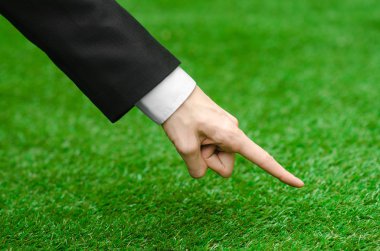 Doğa ve iş Konu: yeşil çim siyah elbiseli adam el gösterir