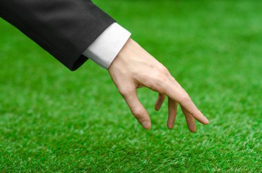 Doğa ve iş Konu: yeşil çim siyah elbiseli adam el gösterir