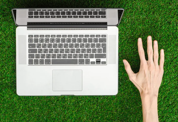 Tema de trabajo al aire libre: la mano humana muestra gestos y un cuaderno abierto sobre un fondo de hierba verde vista superior — Foto de Stock