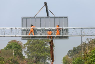 işçiler büyük çelik billboard yüklemek