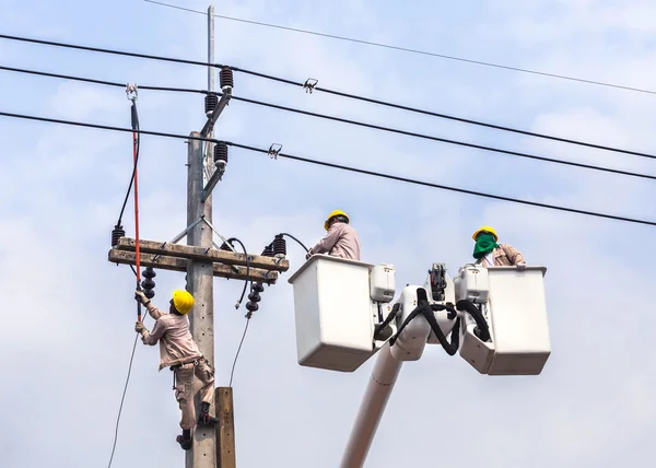 Electricistas reparando el cable de la línea eléctrica en la cesta de elevación hidráulica — Foto de Stock