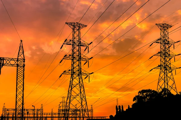 Yüksek gerilim elektrik sütun günbatımı arka plan üzerine