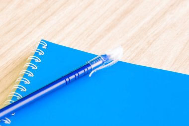 Pen blue and Blank blue book boş cover book spiral kırtasiye okulu malzemeleri eğitim işi fikri kitabı kapak tasarımı not defteri notları ahşap arkaplan.