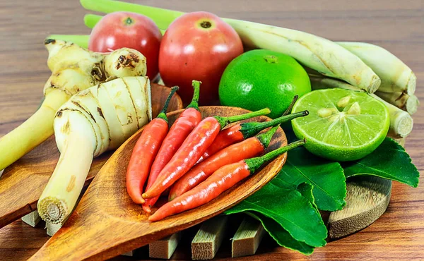 kaffir limon yaprağı, limon, limon otu, galangal, chili, bitki ve baharatlı malzemeler ahşap arka planda Tayland yemeği yapmak için.