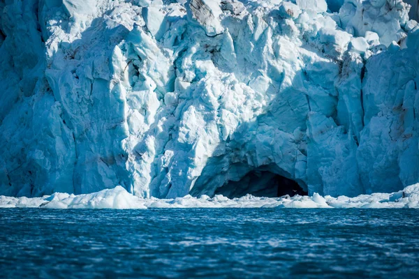 Fågel flyger in i isgrottan i glacier — Stockfoto