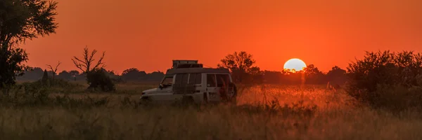 Panorama eines Jeeps, der bei Sonnenuntergang nach Hause fährt — Stockfoto