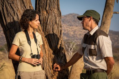 Safari rehberiyle konuşan esmerin yakın çekimi.