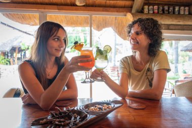 İki esmer bardakları tokuşturur