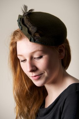 Kızıl saçlı yeşil şapkalı yay ile gülümseyen