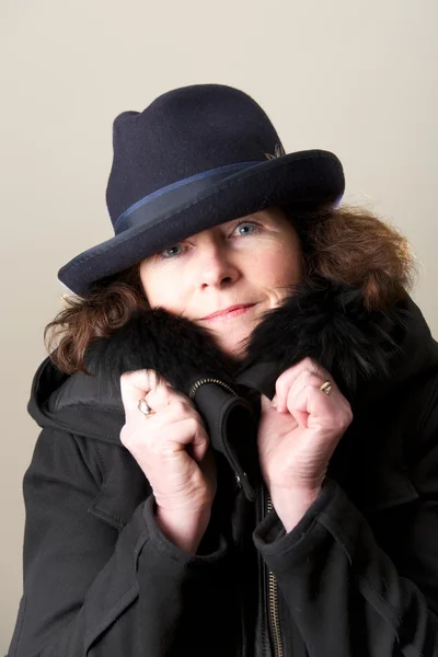 Brunette in blue hat and black jacket — Stock Photo, Image