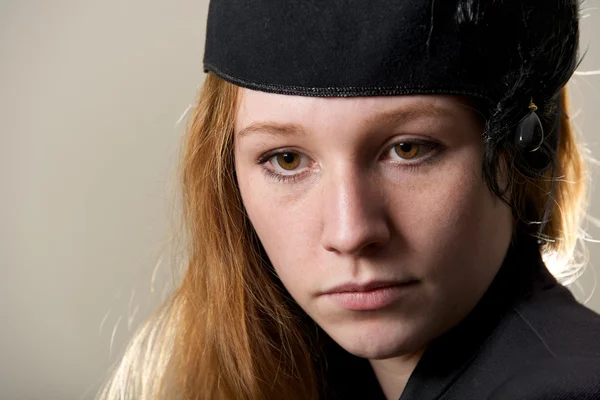 Close-up of serious redhead in black hat — Stock Photo, Image