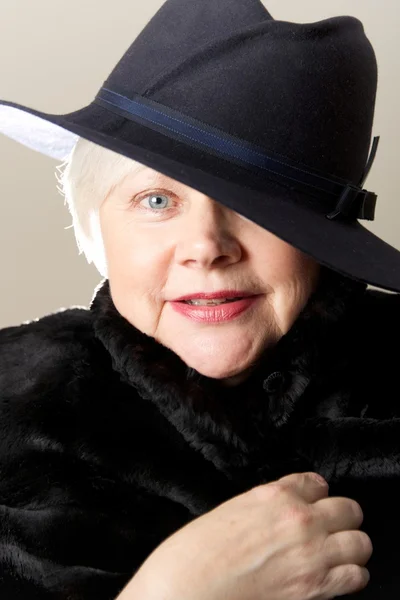 Close-up of white-haired woman in black hat — Stock Photo, Image