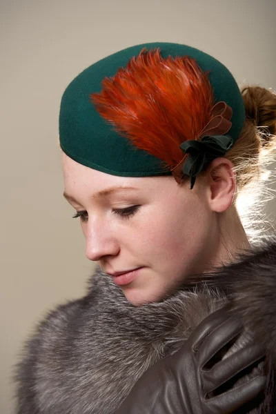 Redhead in green feathered hat and fur — Stock Photo, Image