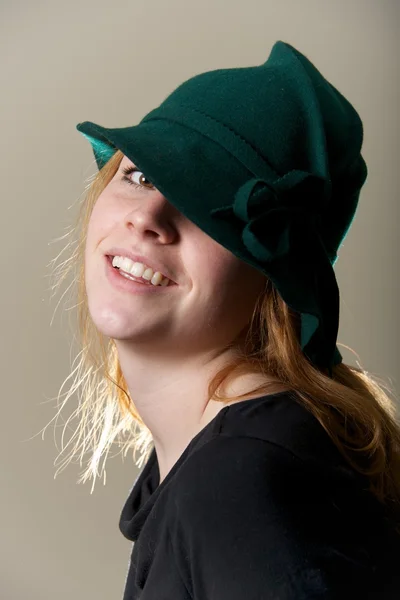 Redhead i grön hatt med huvud lutas — Stockfoto