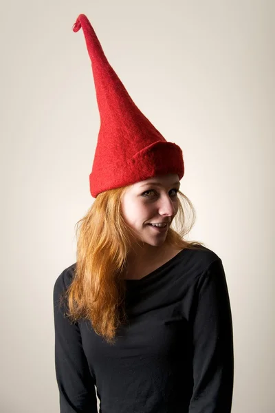 Redhead in red pointed hat turning head — Stock Photo, Image