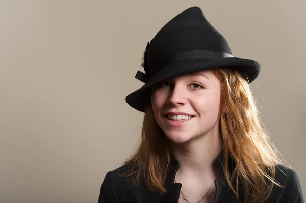 Pelirroja sonriendo en sombrero negro y chaqueta — Foto de Stock