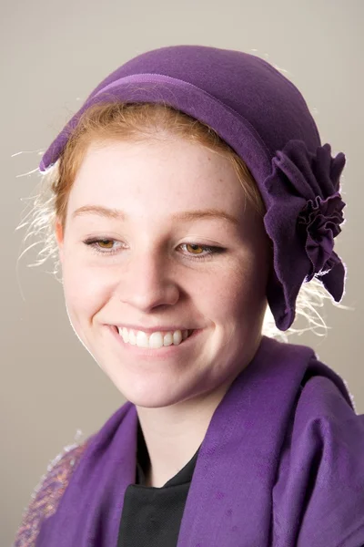 Rousse souriante en chapeau violet lèvre mordante — Photo