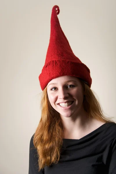 Smiling redhead in tall red pointed hat — Stock Photo, Image