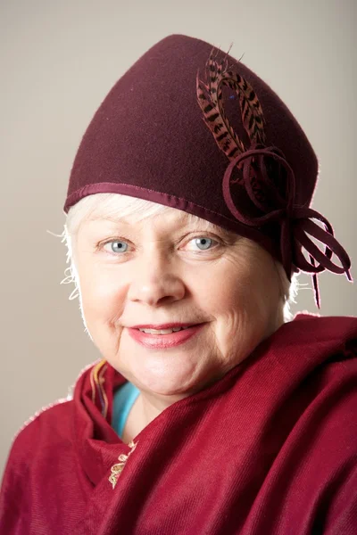 White-haired woman in maroon hat and shawl — Stock Photo, Image