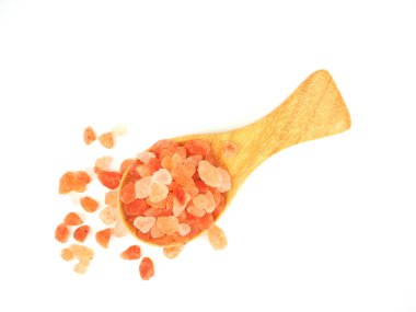 Dümdüz yatıyordu, Üst Manzara, Himalaya pembe tuzu ahşap kaşıkta beyaz arka planda izole edilmiş.