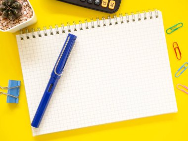 Üst manzara, ofis sarısı iş yeri, defter, kalem, hesap makinesi, kaktüs. Metnin için alanı kopyala. İş ve eğitim kavramı