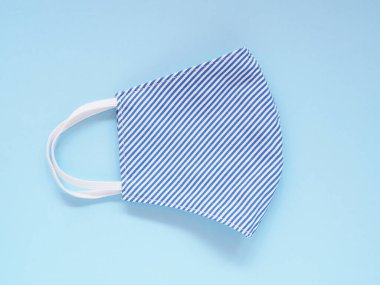 Üst görünüm, kumaş yüz maskesi kirliliği ve virüsleri önlemek için mavi-beyaz çizgiler. Mavi arka planda pamuk muslin el yapımı. Sağlık, Sağlık ve Yeni Normal Konsepti. Metnin için boşluk kopyala