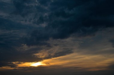 Kara bulutlar, karanlık gökyüzünde bulutlar. Fırtınalı hava, bulutların arasından parlayan güneş..