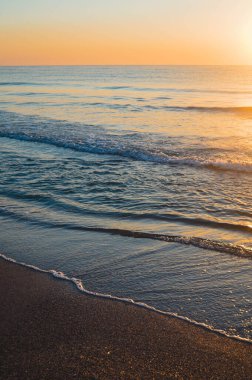 Güzel yaz manzarası, kumsalda gün batımı, parlak kum ve dalgalar, güzel renkler..