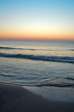 Güzel yaz manzarası, kumsalda gün batımı, parlak kum ve dalgalar, güzel renkler..