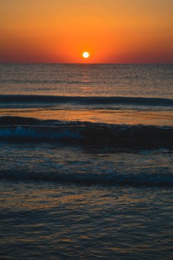 Güzel yaz manzarası, kumsalda gün batımı, parlak kum ve dalgalar, güzel renkler..