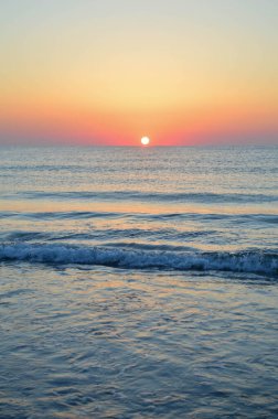 Güzel yaz manzarası, kumsalda gün batımı, parlak kum ve dalgalar, güzel renkler..