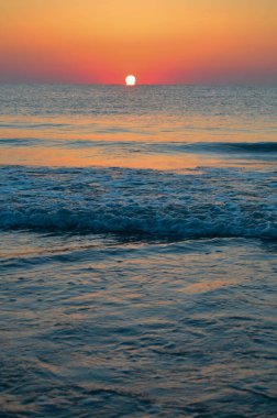 Güzel yaz manzarası, kumsalda gün batımı, parlak kum ve dalgalar, güzel renkler..