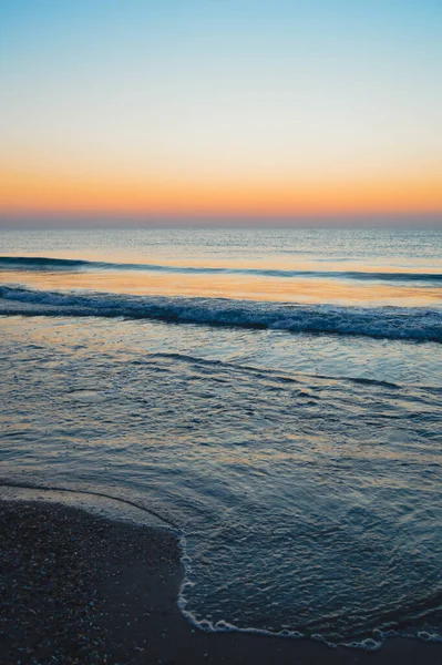 Güzel yaz manzarası, kumsalda gün batımı, parlak kum ve dalgalar, güzel renkler..