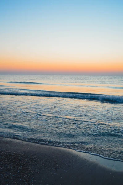 Güzel yaz manzarası, kumsalda gün batımı, parlak kum ve dalgalar, güzel renkler..