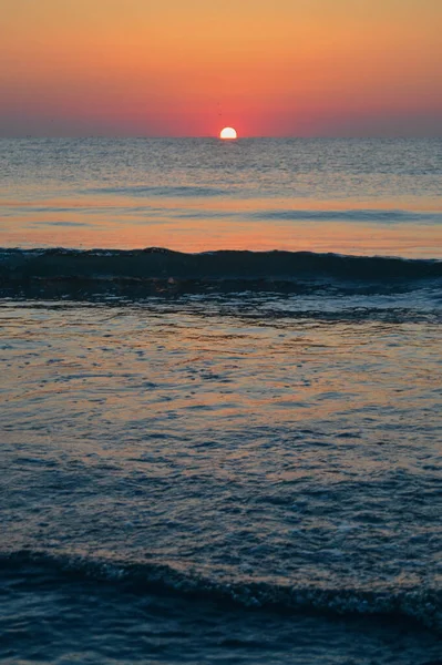 Güzel yaz manzarası, kumsalda gün batımı, parlak kum ve dalgalar, güzel renkler..