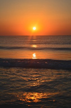 Güzel yaz manzarası, kumsalda gün batımı, parlak kum ve dalgalar, güzel renkler..