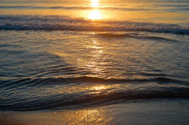 Güzel yaz manzarası, kumsalda gün batımı, parlak kum ve dalgalar, güzel renkler..