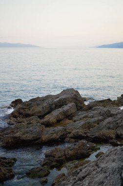 Sahildeki kayalar, sakin su, küçük dalgalar, berrak su..