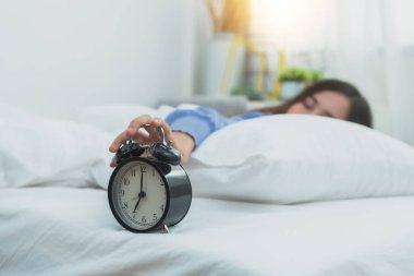 Güzel bir kadın yatakta uyur ve geç kalkar.