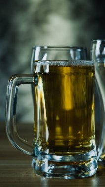 Koyu bira bardakları, ahşap masada soğuk bira bardağı.