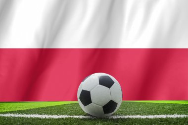 Futbol topu ve Polonya ulusal bayrak yatıyor yeşil çimenlerin üzerinde