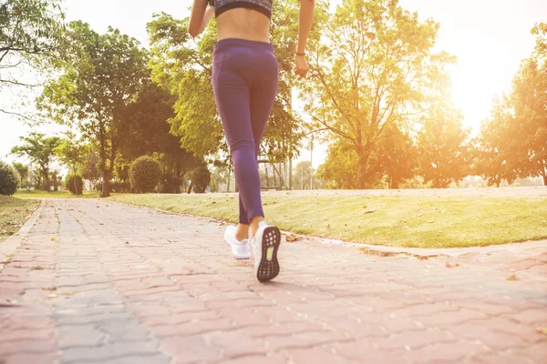 Kvinna joggar ner för en utomhusstig vid solnedgången — Stockfoto