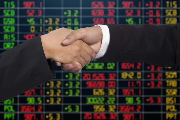 Business handshake on  stock market background — Stock Photo, Image