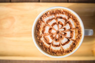 ahşap masa üzerinde bir latte kahve sanat