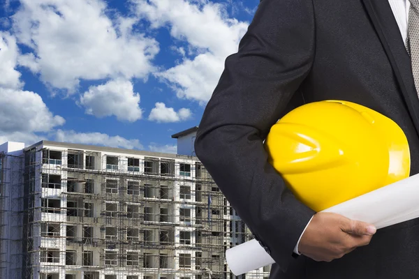 Ingenieur holding helm voor het werken op de voet van het gebouw const — Stockfoto
