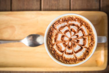 ahşap masa üzerinde bir latte kahve sanat