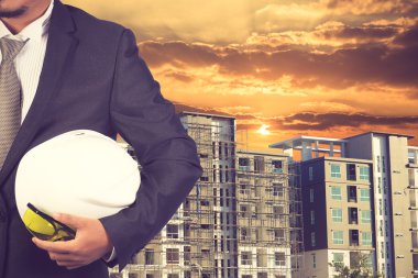 const binanın zemine, çalışmak için kask tutan mühendisi