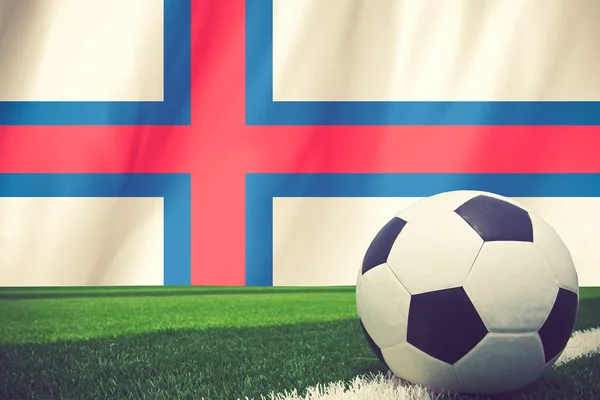 Balón de fútbol y bandera nacional de las Islas Feroe se encuentra en el verde —  Fotos de Stock
