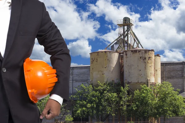 Engineer holding helmet working at high building construction si — Stock Photo, Image