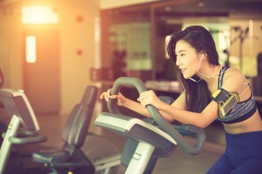 Mutlu kadın spor salonunda egzersiz bisikleti binme. Vintage renk